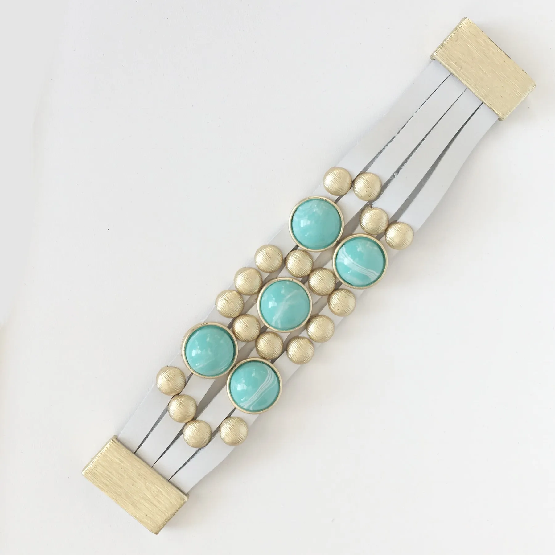 Bursting Goldtone Beads and Turquoise Resin Accents Adorn this White Leather Bracelet with Magnetic Clasp